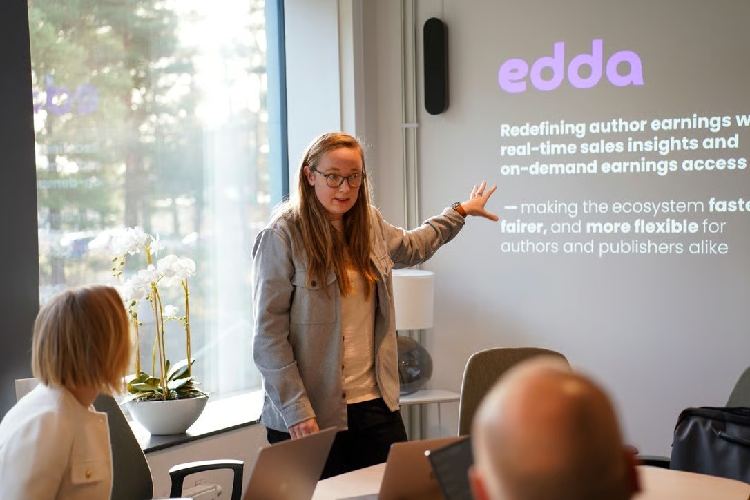 A presenter pointing at an Edda slide during pitch training at the incubator